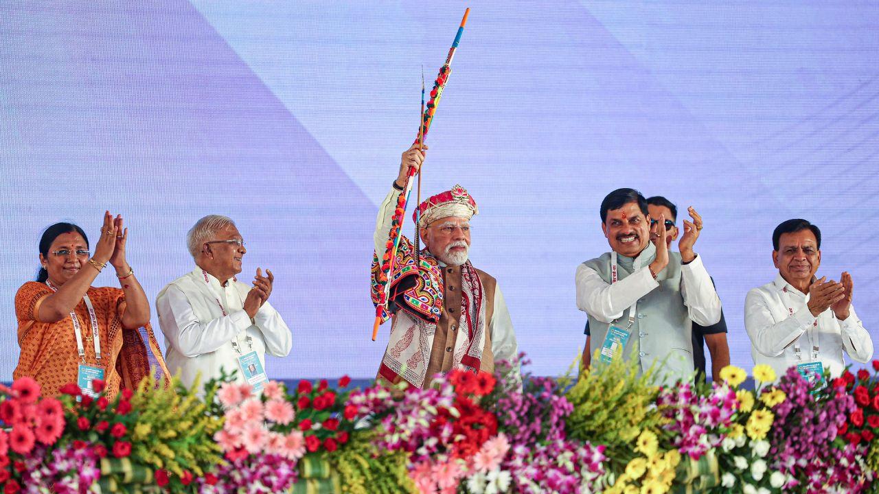 Prime Minister Narendra Modi holds a bow and arrow during the foundation stone laying ceremony of the PM MITRA Park.